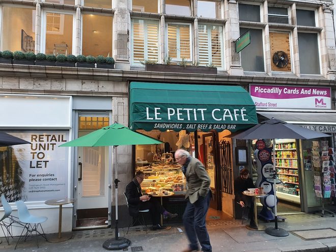 The café's green awning and pavement tables
